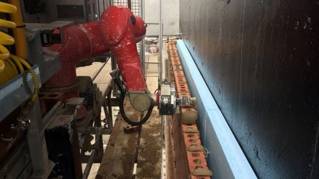 Six-axis robot laying bricks: six times faster than a bricklayer.